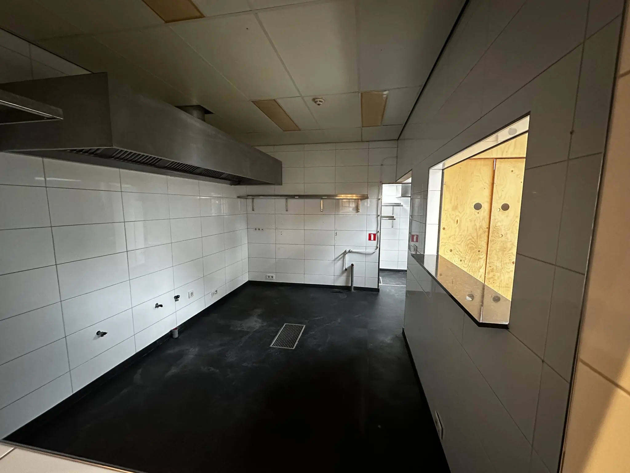 Lege professionele keuken met witte tegelwanden en een grote afzuigkap aan het Sint-Agathaplein.